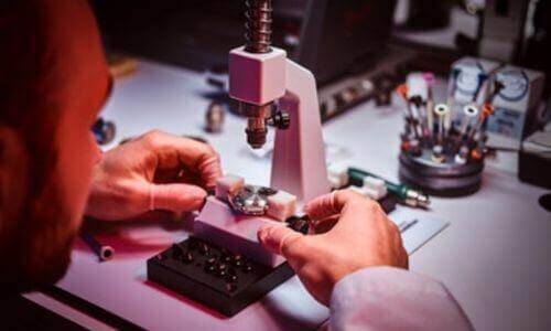 orologiaio che con il suo strumento ripara un orologio